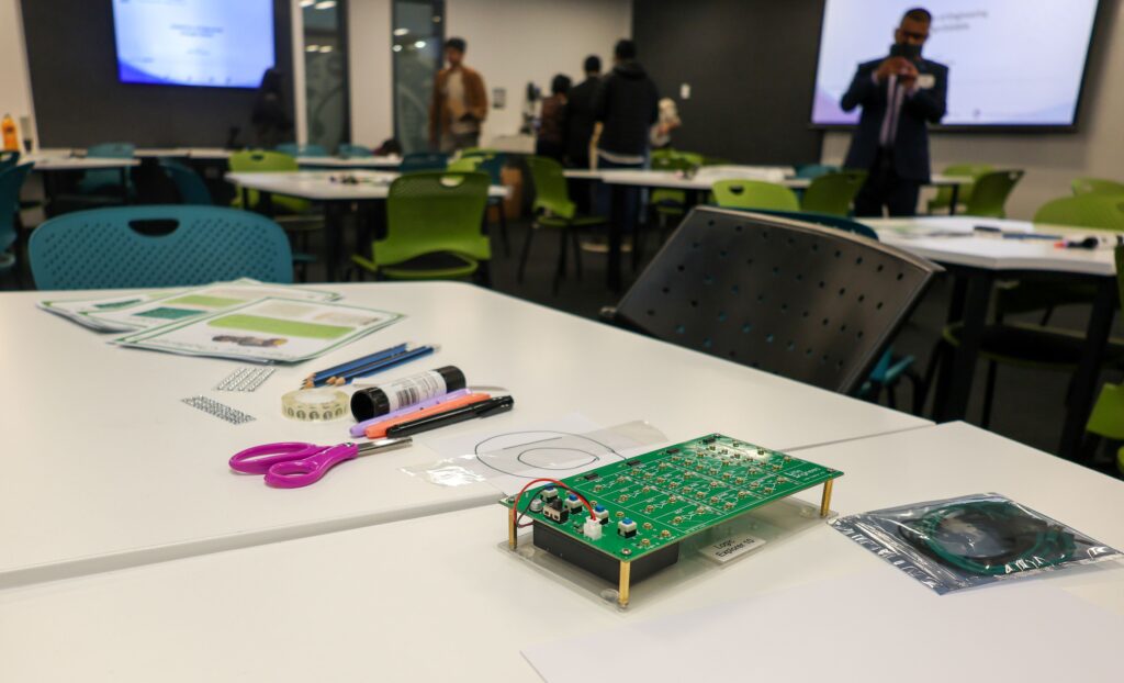 Electronics project on a table at the UoA Open Day with workshop materials.
