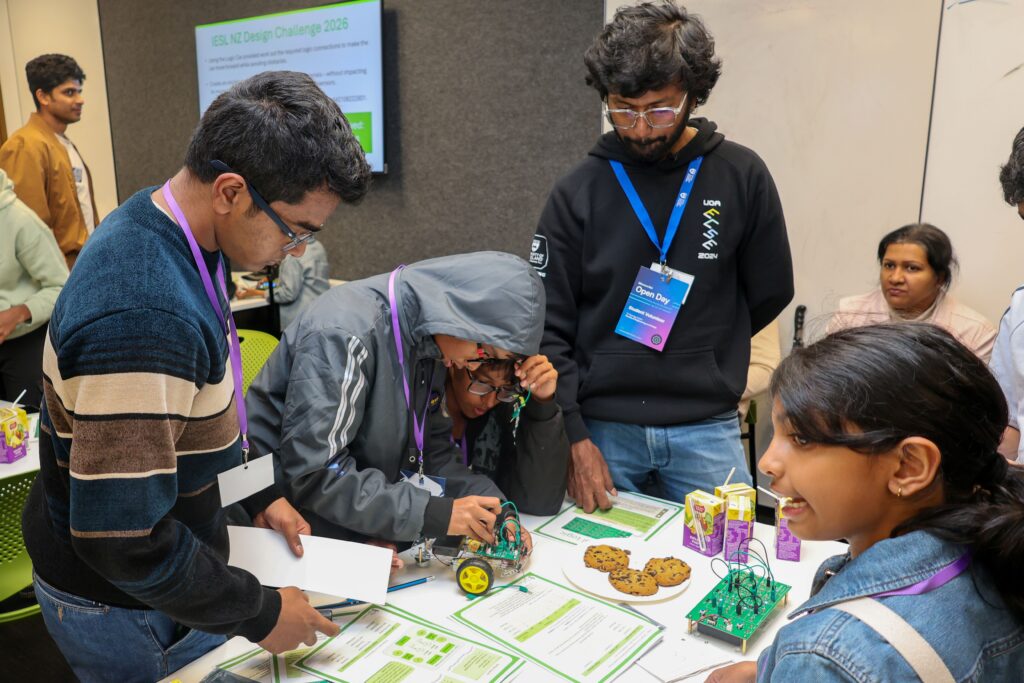 Young students and mentors engaging in a robotics activity at the UoA Open Day.