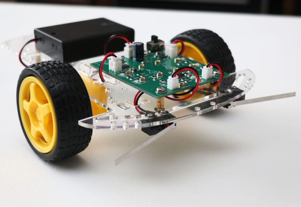 Educational robot with yellow wheels and electronic components for STEM learning.